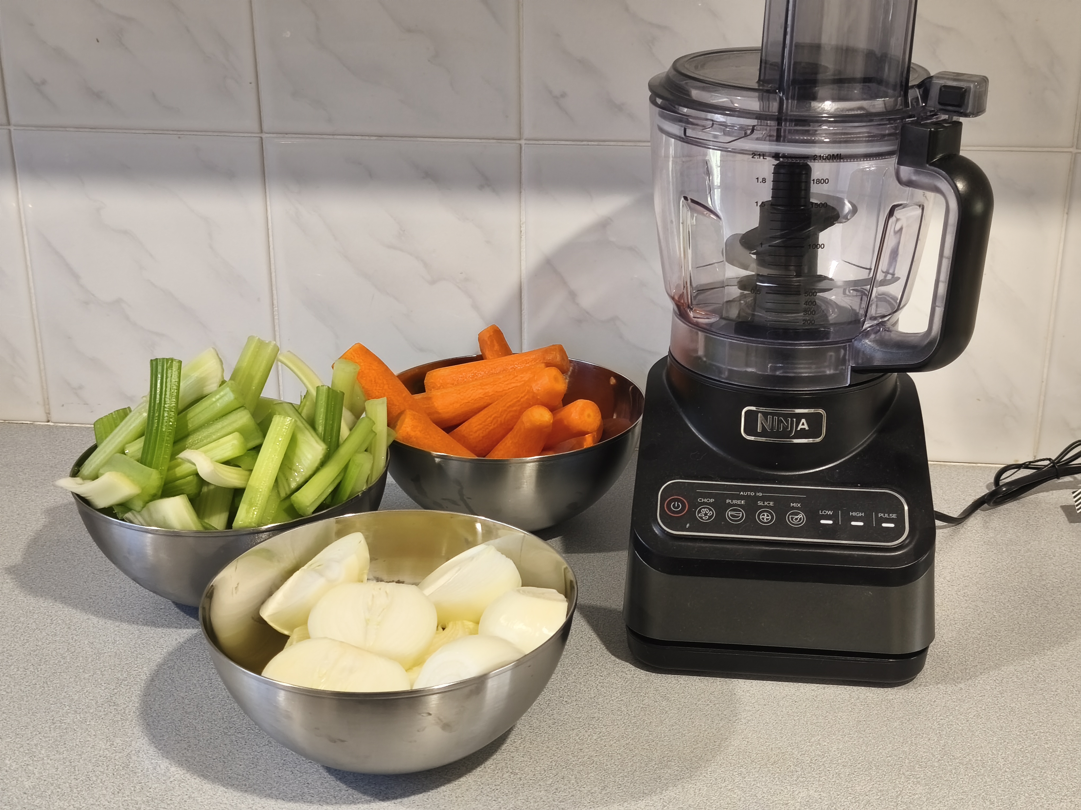 Step 2: Cut onion into quarters, celery into stalks, and peel carrots, while the mince is browning.